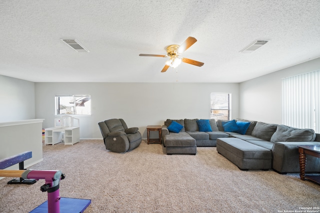 carpeted living room featuring ceiling fan, a healthy amount of sunlight, and a textured ceiling