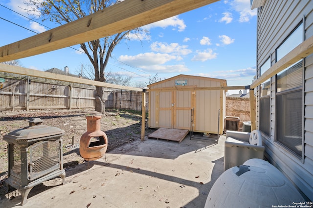 view of patio featuring cooling unit and a shed