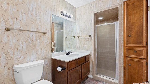 bathroom with a shower with door, vanity, and toilet