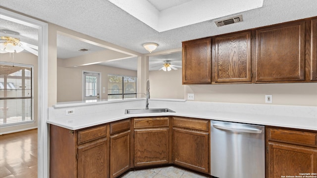 kitchen with dishwasher, a textured ceiling, ceiling fan, and sink