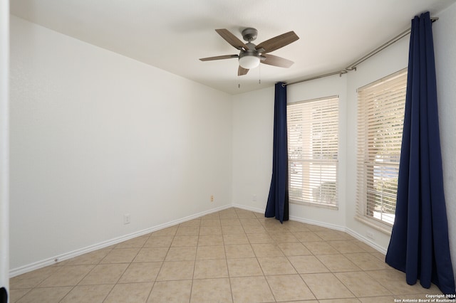 tiled spare room with ceiling fan