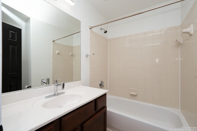 bathroom featuring tiled shower / bath combo and vanity