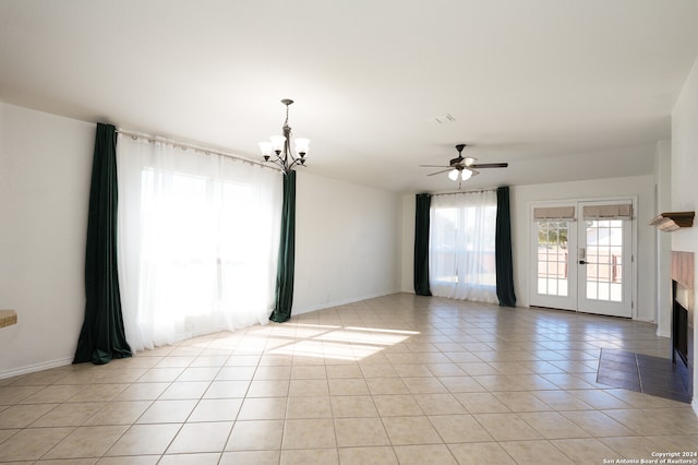 unfurnished room with light tile patterned floors and ceiling fan with notable chandelier