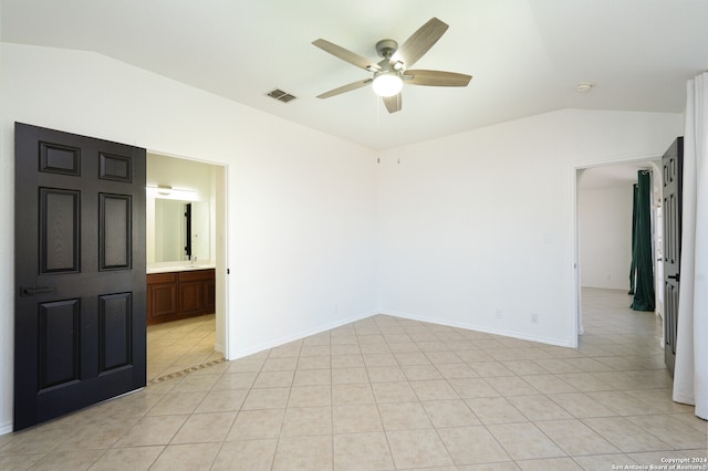 unfurnished room with ceiling fan, light tile patterned flooring, and vaulted ceiling