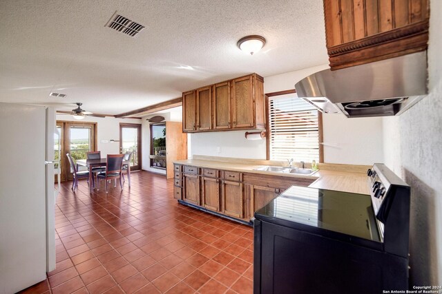 kitchen with ceiling fan, stainless steel electric stove, sink, white refrigerator, and dark tile patterned flooring