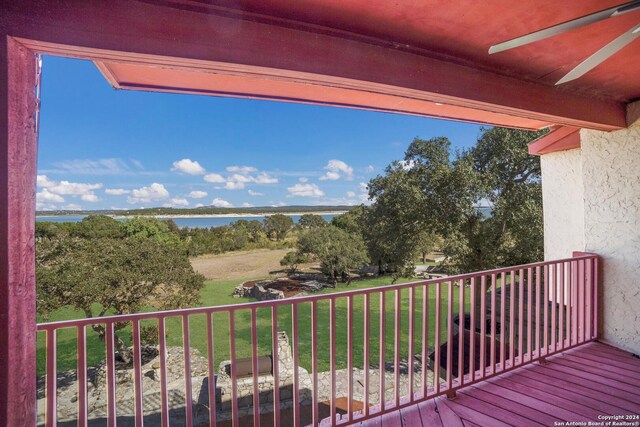 balcony featuring ceiling fan and a water view