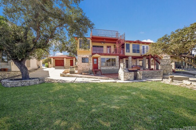 back of property with a lawn, a balcony, and central AC unit