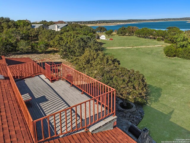 wooden deck featuring a water view and a lawn