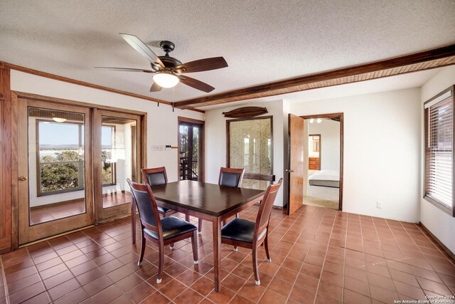 tiled dining area with ceiling fan, a healthy amount of sunlight, crown molding, and a textured ceiling