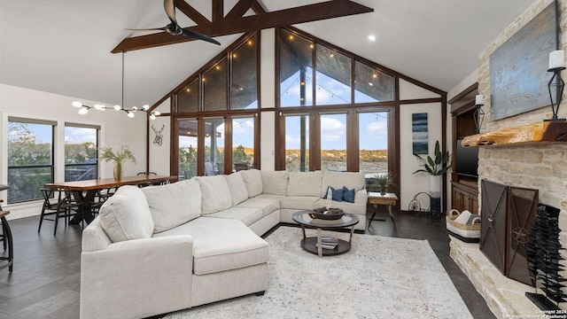 living room featuring hardwood / wood-style flooring, ceiling fan, a stone fireplace, and high vaulted ceiling