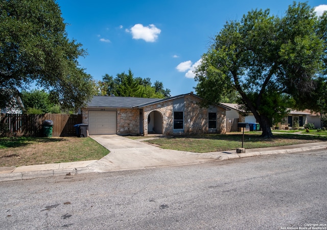 ranch-style house featuring a garage and a front lawn