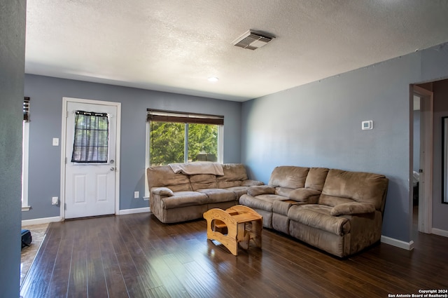 living room featuring dark hardwood / wood-style flooring and a textured ceiling