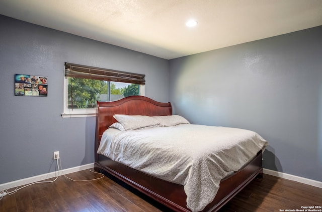 bedroom with dark hardwood / wood-style flooring