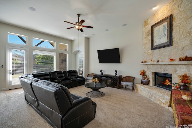 living room with ceiling fan, a fireplace, and light colored carpet