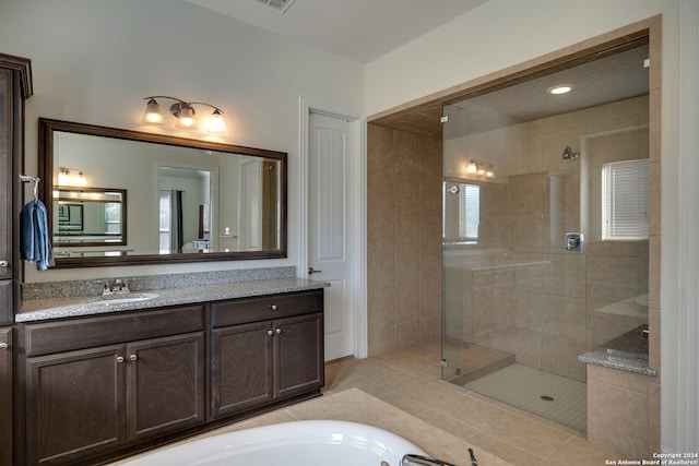 bathroom with tile patterned flooring, vanity, and separate shower and tub