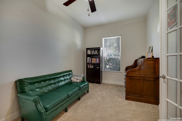 sitting room with ceiling fan and light colored carpet