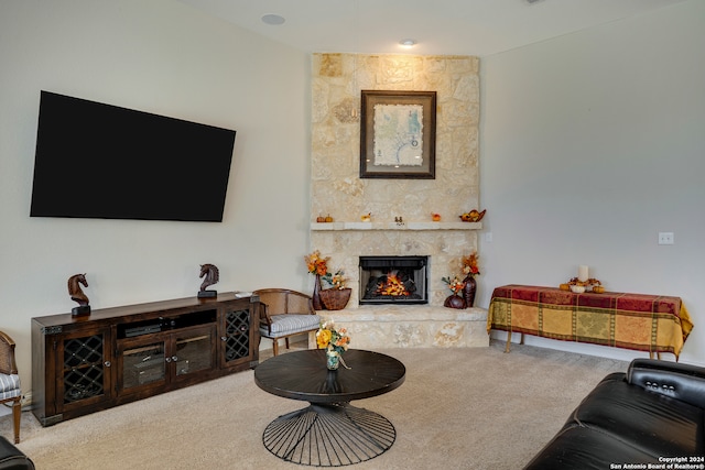 living room featuring a stone fireplace and carpet floors