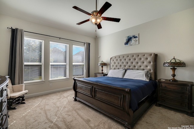 bedroom featuring multiple windows, ceiling fan, and light colored carpet