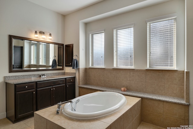 bathroom featuring vanity, a relaxing tiled tub, and tile patterned floors