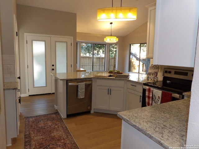 kitchen featuring light wood-type flooring, electric range oven, stainless steel dishwasher, decorative light fixtures, and white cabinetry