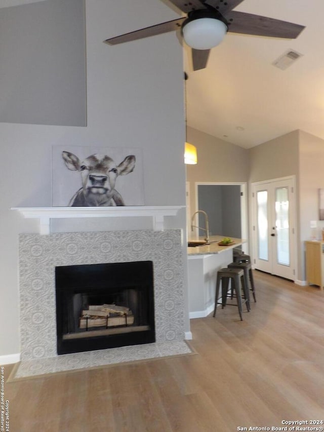 room details with french doors, ceiling fan, sink, a fireplace, and hardwood / wood-style floors