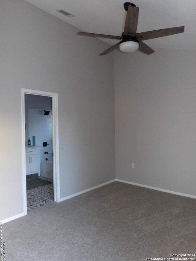 carpeted spare room featuring ceiling fan and vaulted ceiling