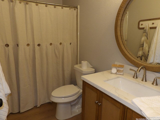 bathroom with wood-type flooring, vanity, and toilet