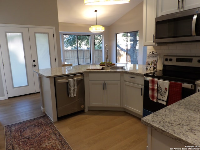 kitchen featuring white cabinetry, hanging light fixtures, and appliances with stainless steel finishes