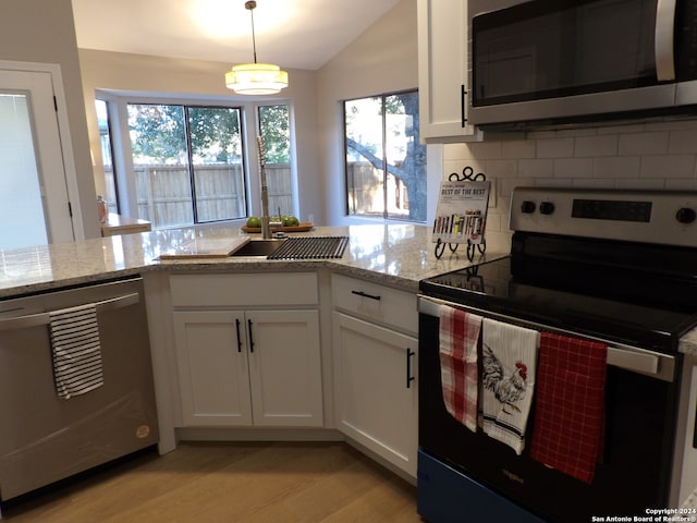 kitchen with white cabinets, pendant lighting, stainless steel appliances, and plenty of natural light