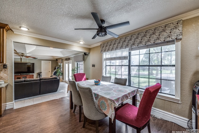 dining room featuring ceiling fan, wood-type flooring, a textured ceiling, and ornamental molding