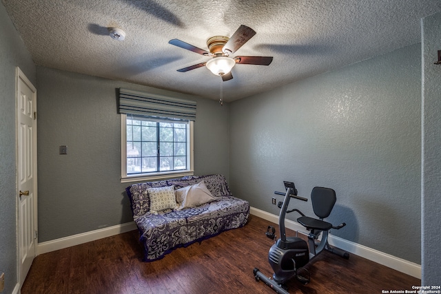 workout room featuring ceiling fan, wood-type flooring, and a textured ceiling