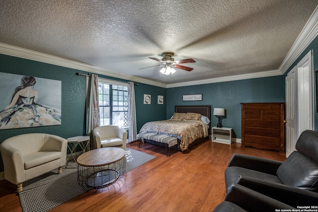 bedroom with ceiling fan, hardwood / wood-style floors, crown molding, and a textured ceiling