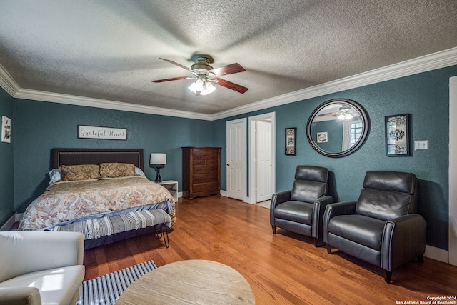 bedroom featuring ceiling fan, wood-type flooring, a textured ceiling, and ornamental molding