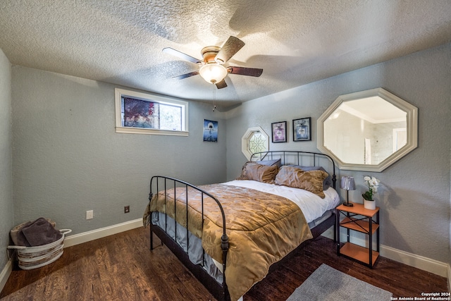 bedroom with a textured ceiling, ceiling fan, and dark hardwood / wood-style floors