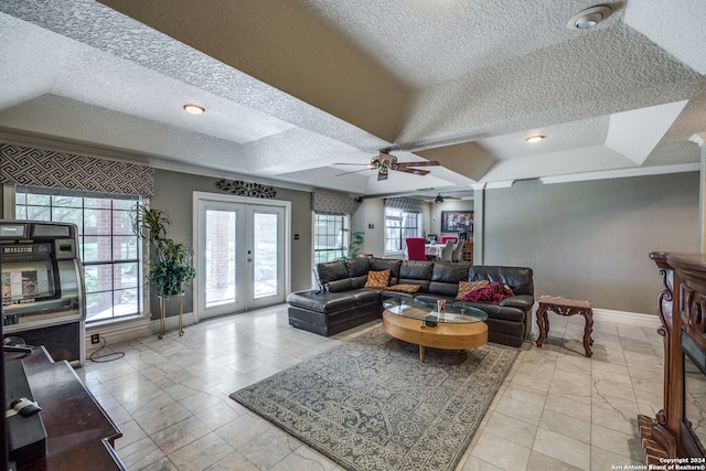 living room with ceiling fan, french doors, and a textured ceiling