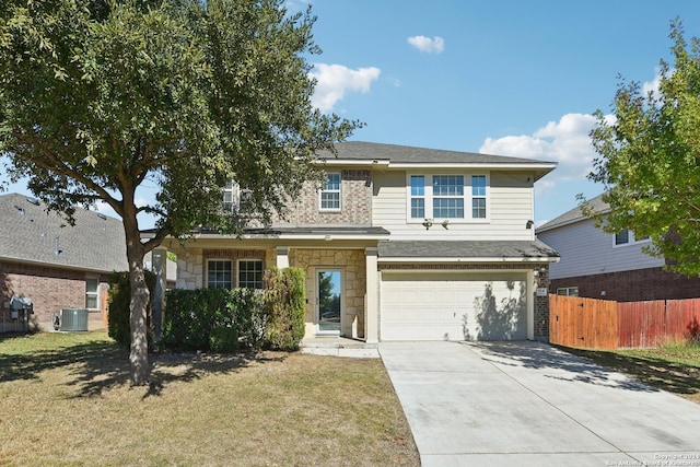 front facade featuring a front yard, a garage, and central air condition unit