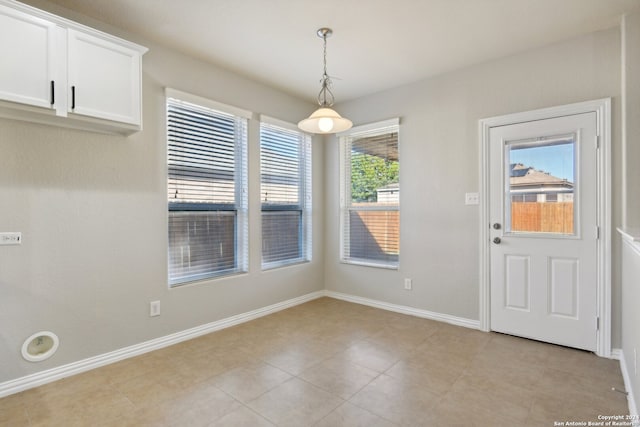 unfurnished dining area featuring a wealth of natural light and light tile patterned flooring