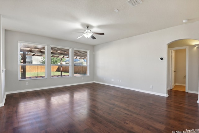 unfurnished room featuring ceiling fan, dark wood-type flooring, and a textured ceiling