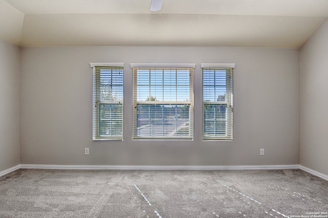 carpeted spare room with vaulted ceiling