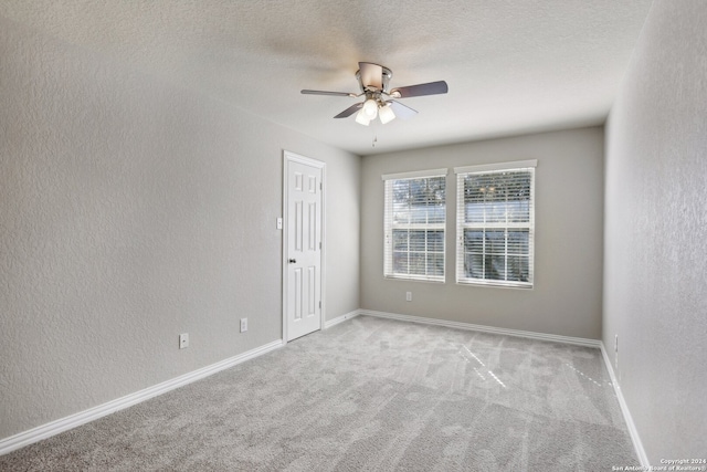 carpeted empty room featuring a textured ceiling and ceiling fan