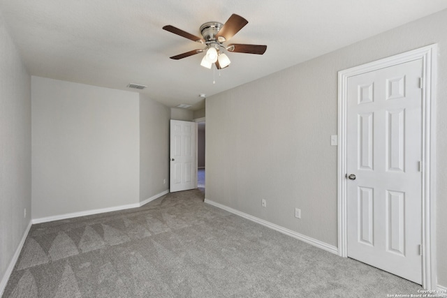 empty room featuring ceiling fan and light colored carpet