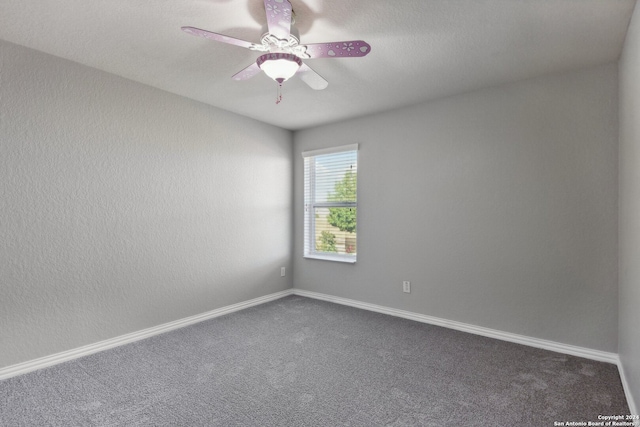 empty room with ceiling fan and dark colored carpet