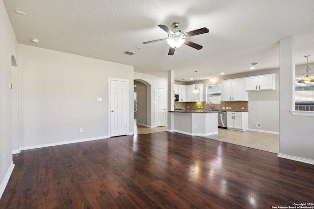 unfurnished living room with a textured ceiling, ceiling fan, dark wood-type flooring, and sink