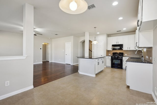 kitchen with black appliances, white cabinets, sink, hanging light fixtures, and light hardwood / wood-style floors