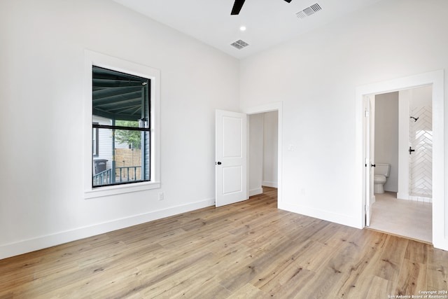 unfurnished bedroom with light wood-type flooring, ensuite bathroom, and ceiling fan