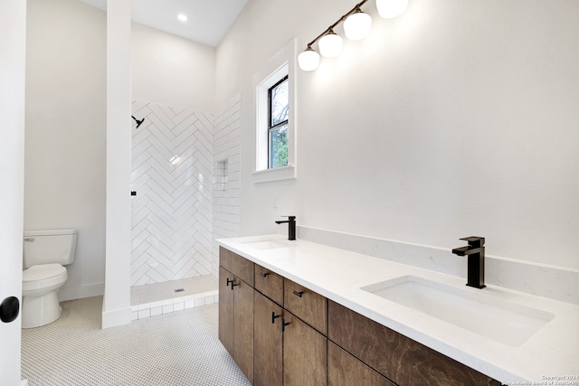 bathroom featuring tile patterned flooring, vanity, toilet, and a tile shower