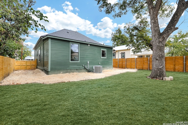 back of property with a lawn and cooling unit