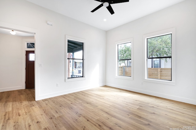 spare room with ceiling fan, plenty of natural light, and light wood-type flooring