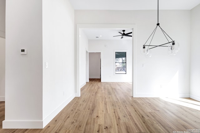 interior space featuring light hardwood / wood-style floors and ceiling fan with notable chandelier