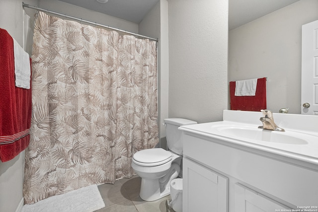 bathroom with tile patterned floors, walk in shower, vanity, and toilet